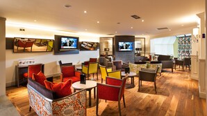 Een moderne zithoek met comfortabele zitplaatsen, een flatscreen televisie en een goed verlichte ruimte.