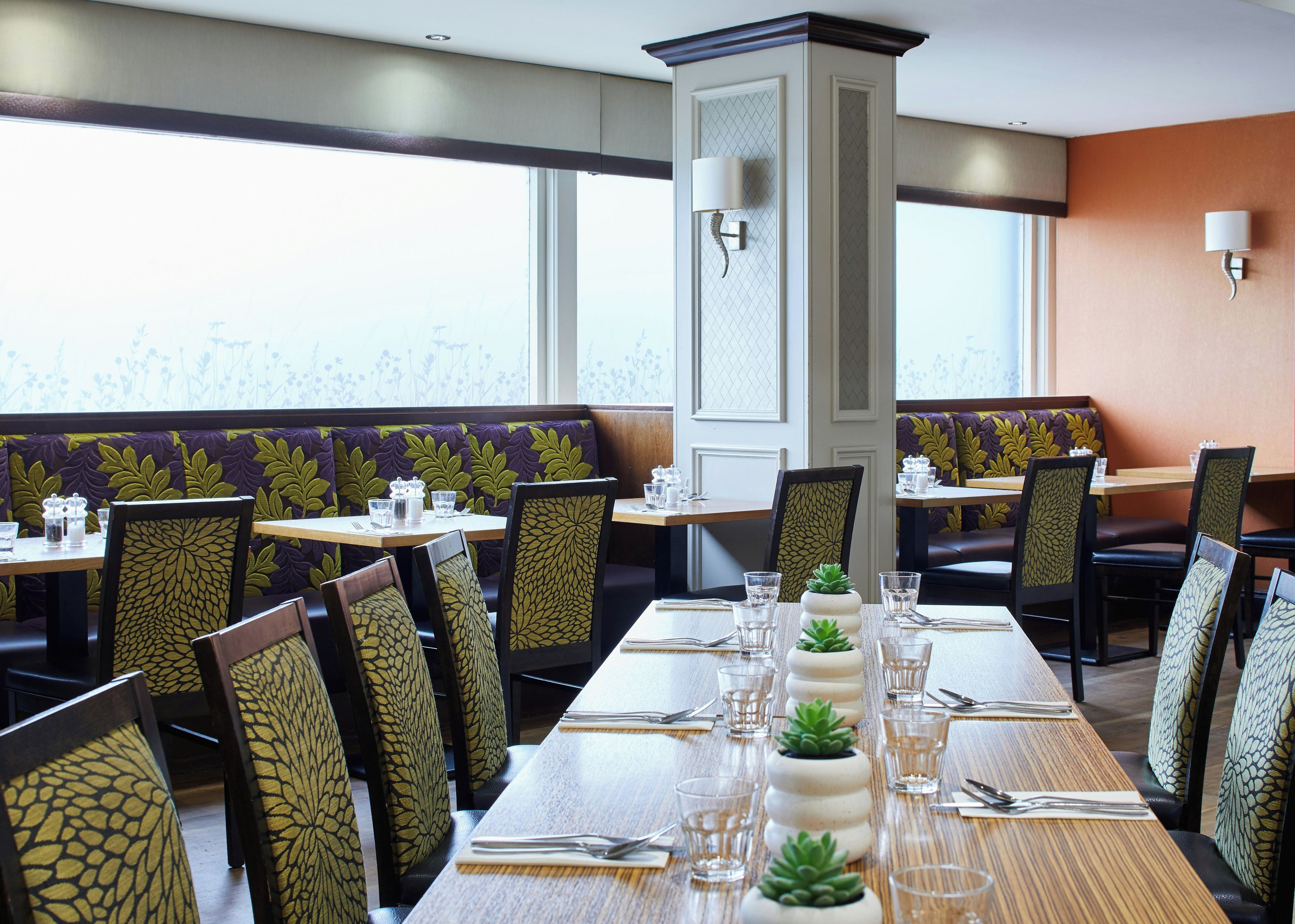 A restaurant with booths, tables, and chairs.