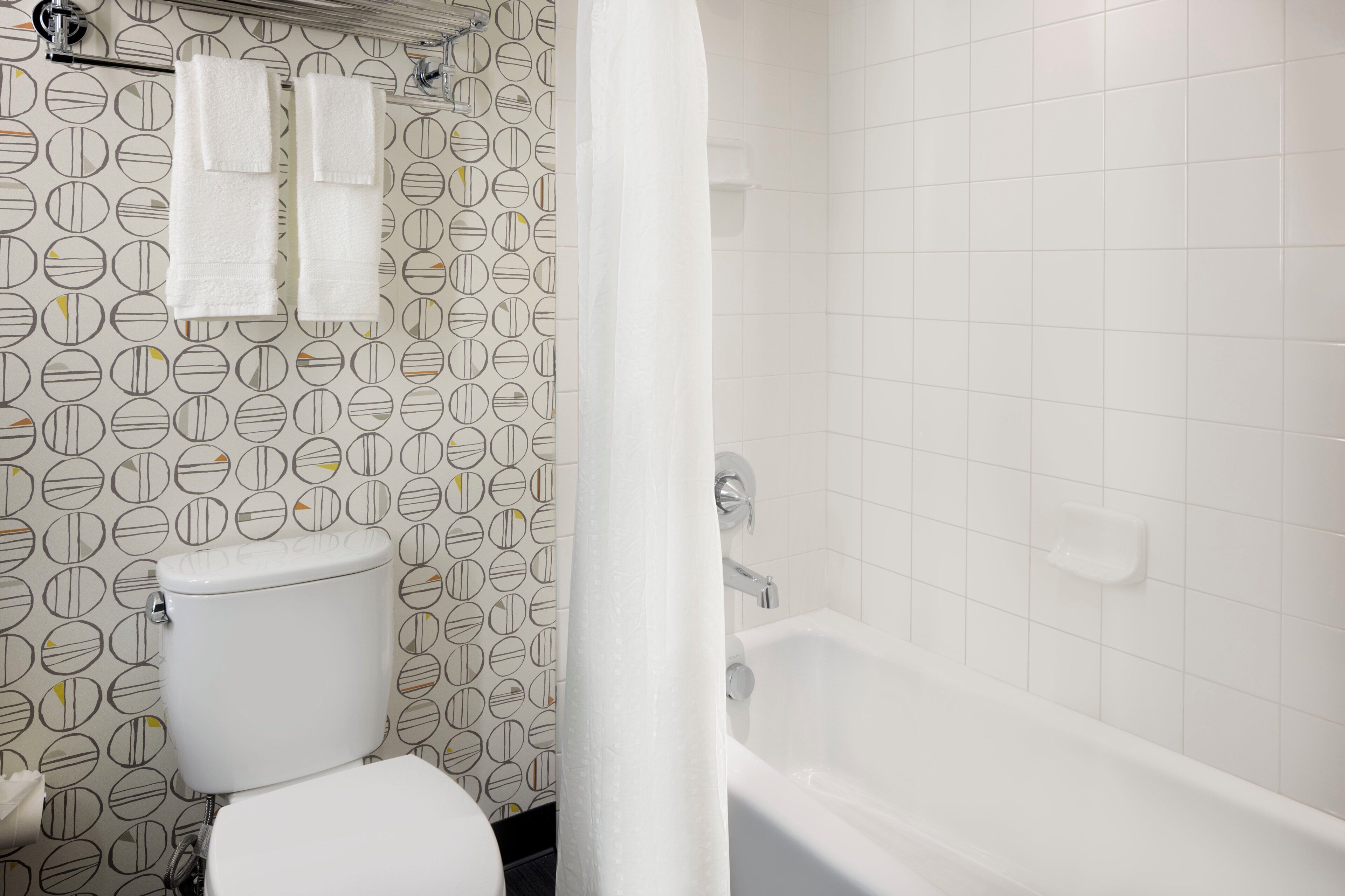 Une salle de bain équipée de toilettes, d’une baignoire et d’un rideau de douche.