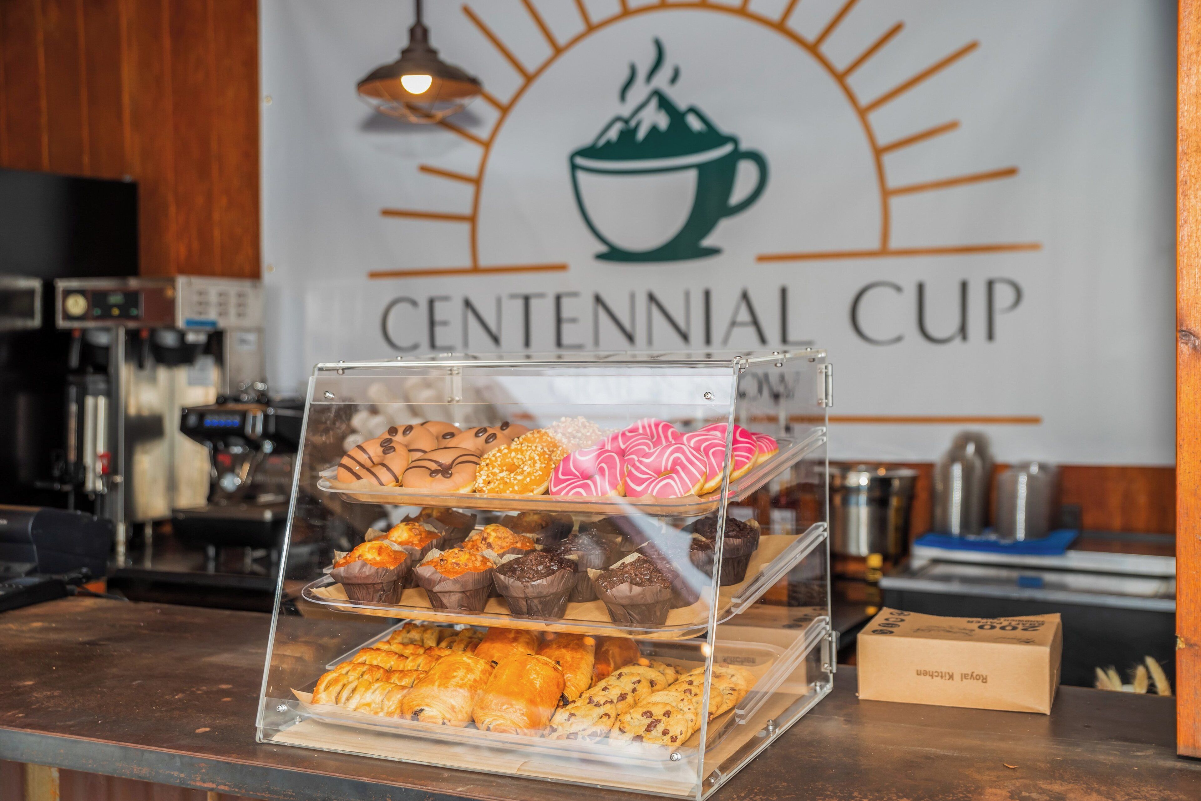 Una vetrina di pasticceria con diversi dolci e una macchina da caffè sullo sfondo.