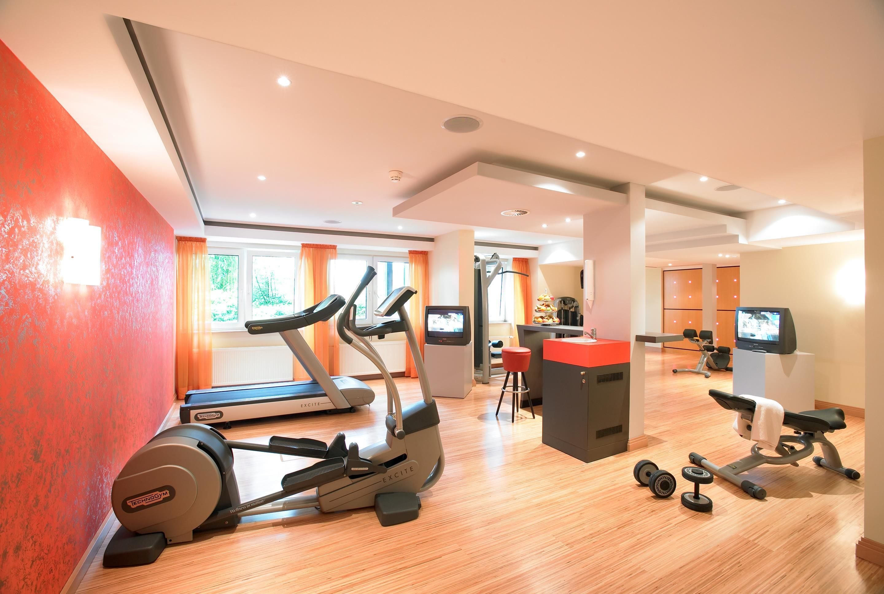 A gym with treadmills, a stationary bike, and a weight bench.