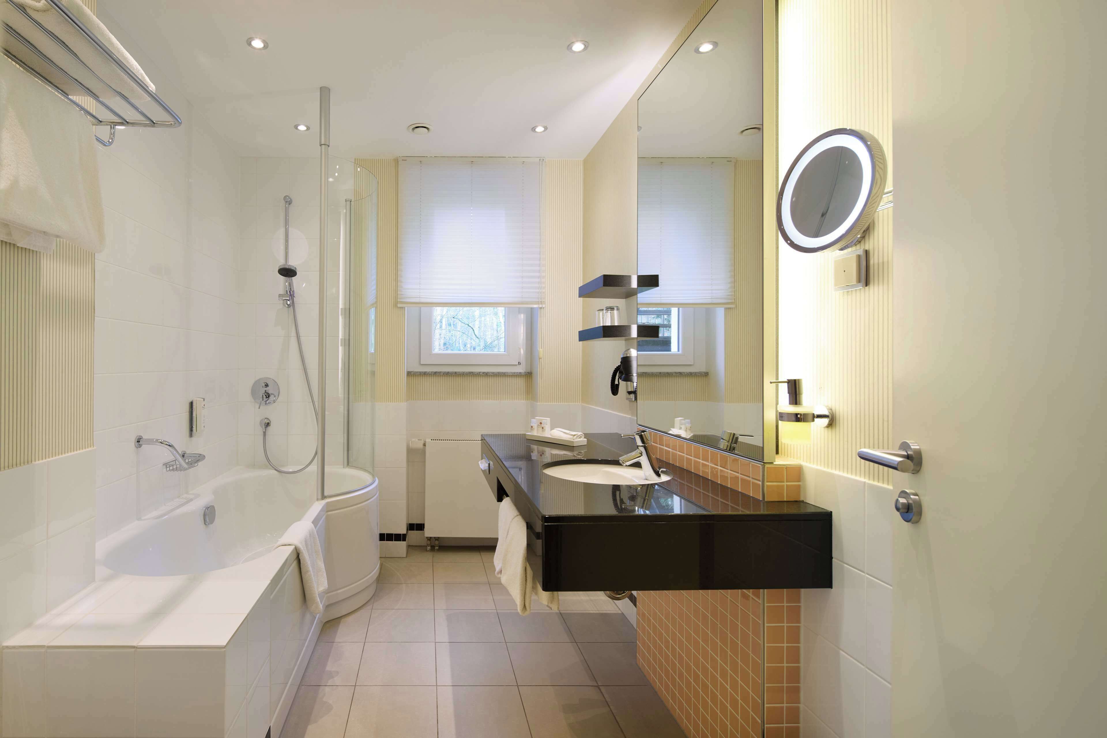 Une salle de bain moderne avec une baignoire, un lavabo et un miroir.