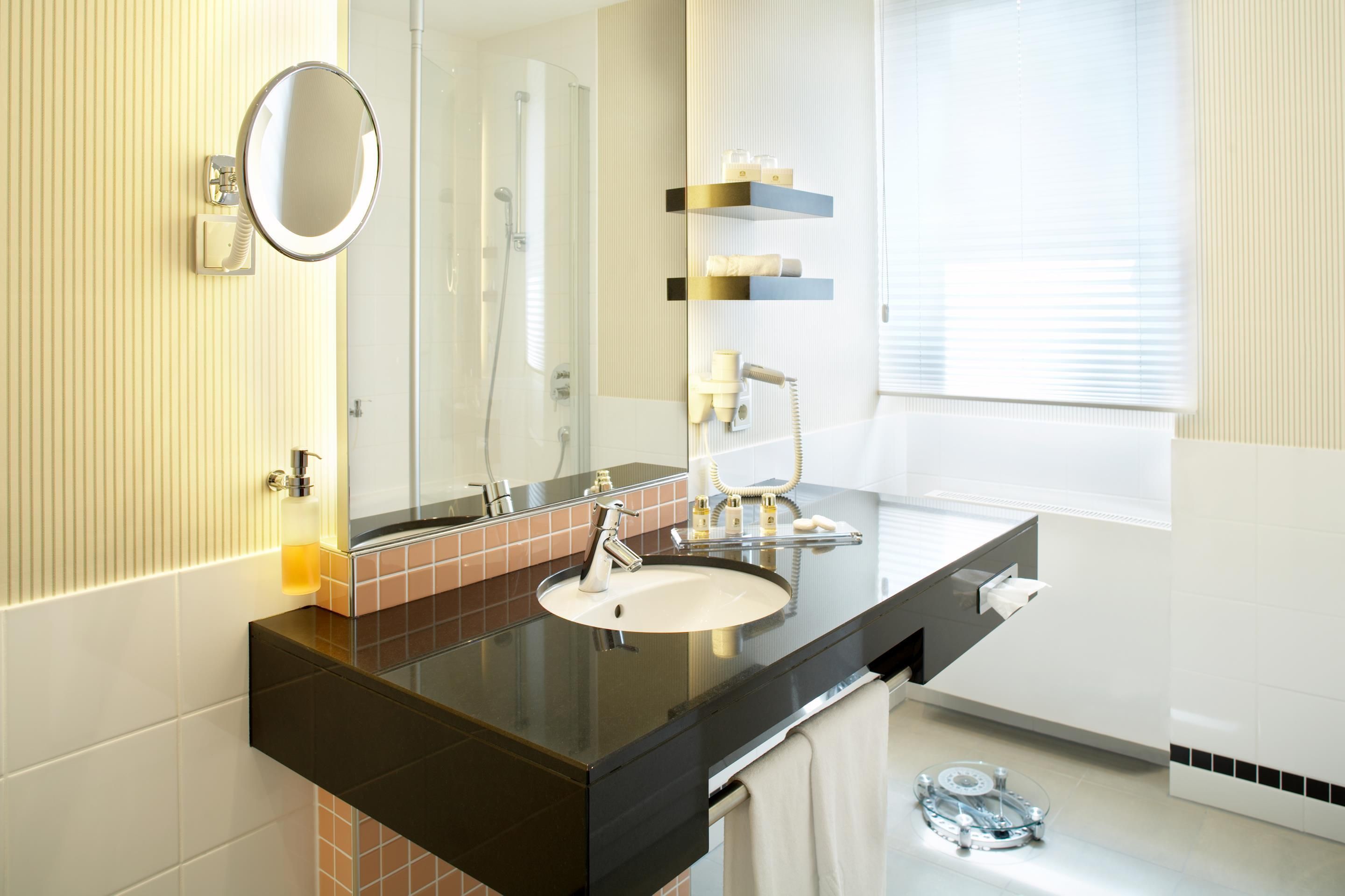 Un baño moderno con lavamanos doble, un espejo grande y un perchero para toallas.