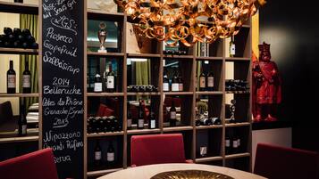 Ein Restaurantinneres mit Weinkühlschrank, einer roten Statue und einer Kreidetafel-Speisekarte.