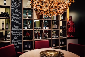 A restaurant interior with a wine rack, a red statue, and a chalkboard menu. - Best Western Premier Park Hotel and Spa (Bad Lippspringe)