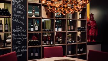 Ein Weinkeller mit Weinregalen, einer Tafel mit Informationen über Wein und einer Statue.