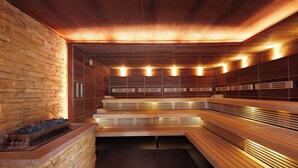 A sauna with wooden benches and a stone wall. - Best Western Premier Park Hotel and Spa (Bad Lippspringe)