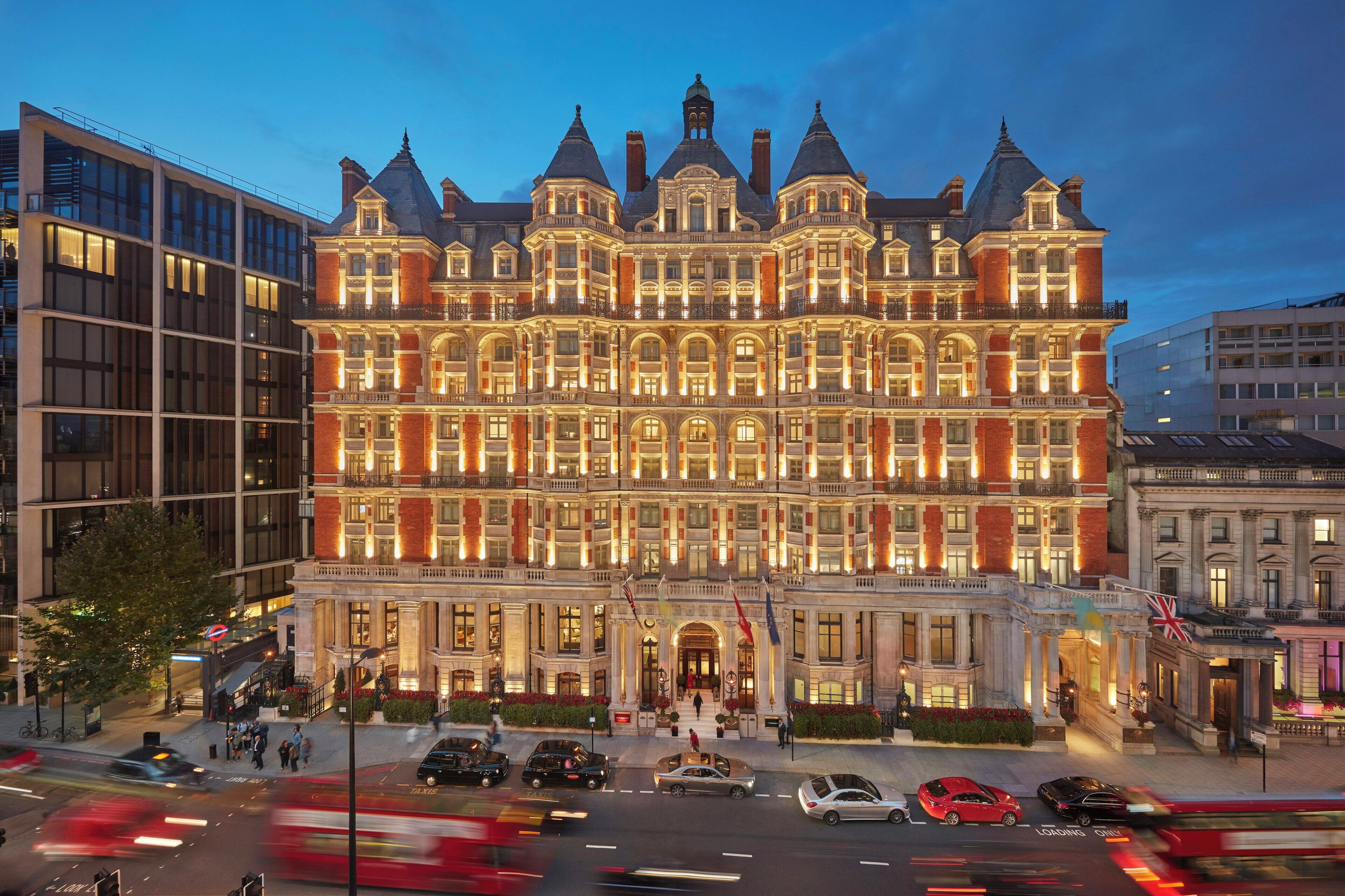 A large, historic building with multiple stories, prominent architectural details, and a well-lit facade.