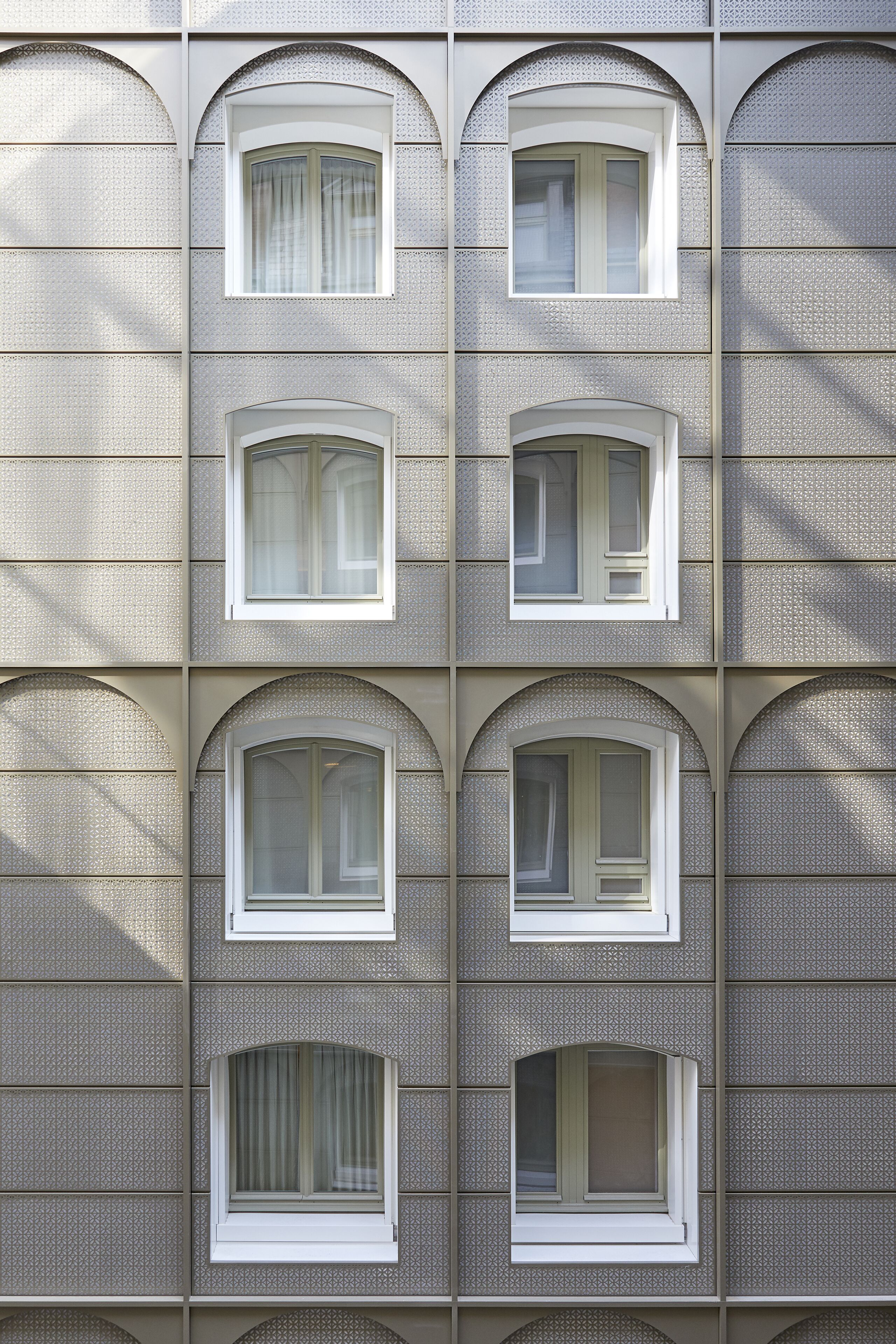 A building facade with multiple arched windows and a textured wall pattern.