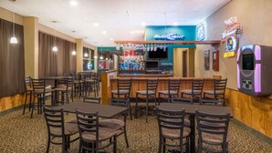 A restaurant with multiple tables and chairs, a bar area with a Bud Light sign, and a jukebox. - Days Inn by Wyndham Kirksville (Kirksville)