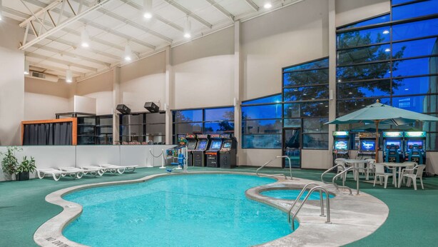 An indoor swimming pool with a no diving sign, surrounded by lounge chairs and gaming machines. - Days Inn by Wyndham Kirksville (Kirksville)