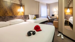 Habitación de hotel con dos camas, un escritorio, una silla, una computadora portátil, un teléfono y un espejo.