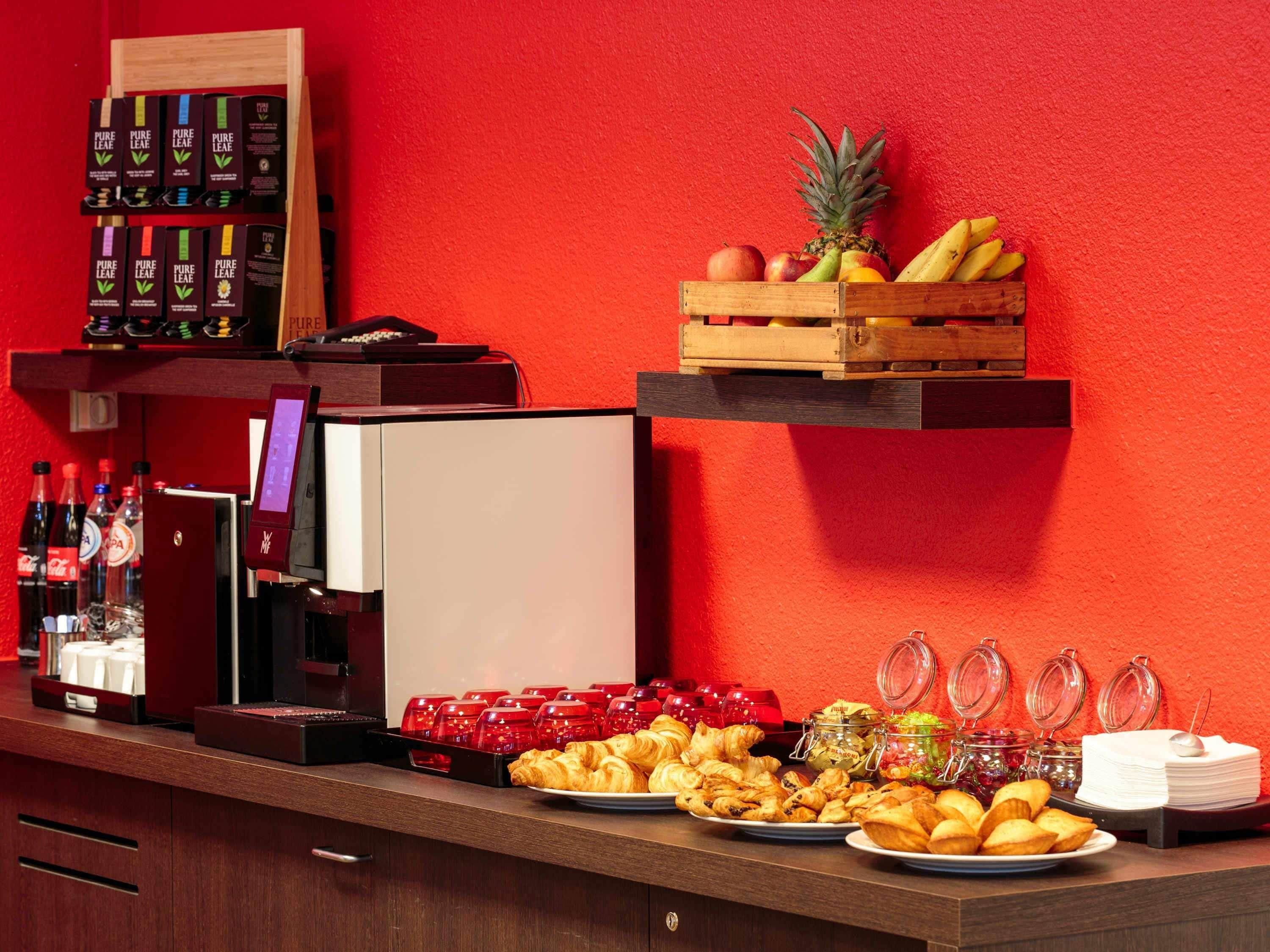 A breakfast buffet with pastries, fruits, and beverages.