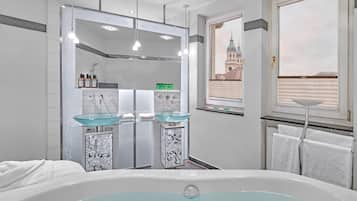 Ein modernes Badezimmer mit einer Duschkabine, zwei Waschbecken, einer Badewanne und Blick auf ein Gebäude durch ein Fenster.