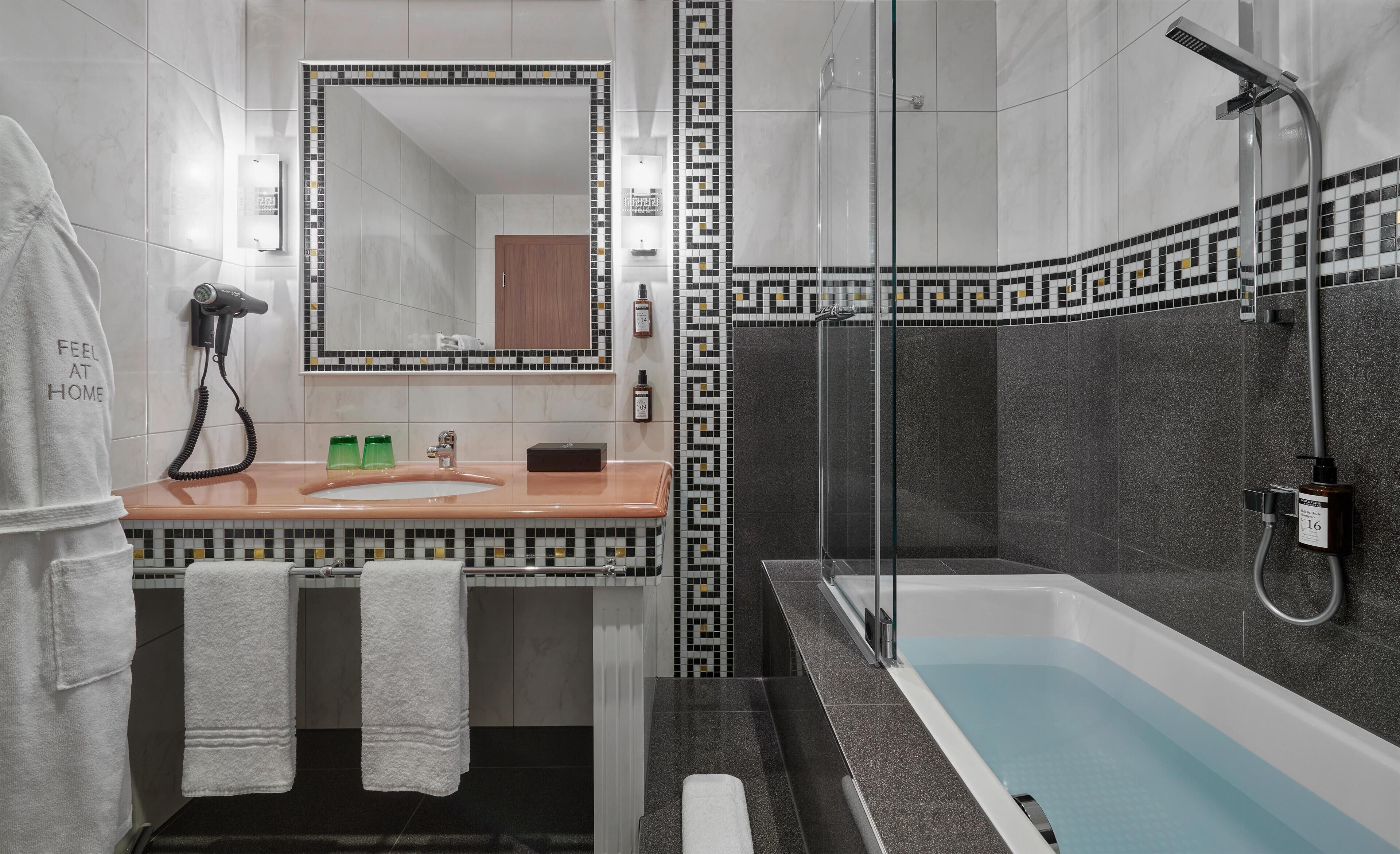A modern bathroom with a large bathtub, a shower, and a vanity with a mirror.