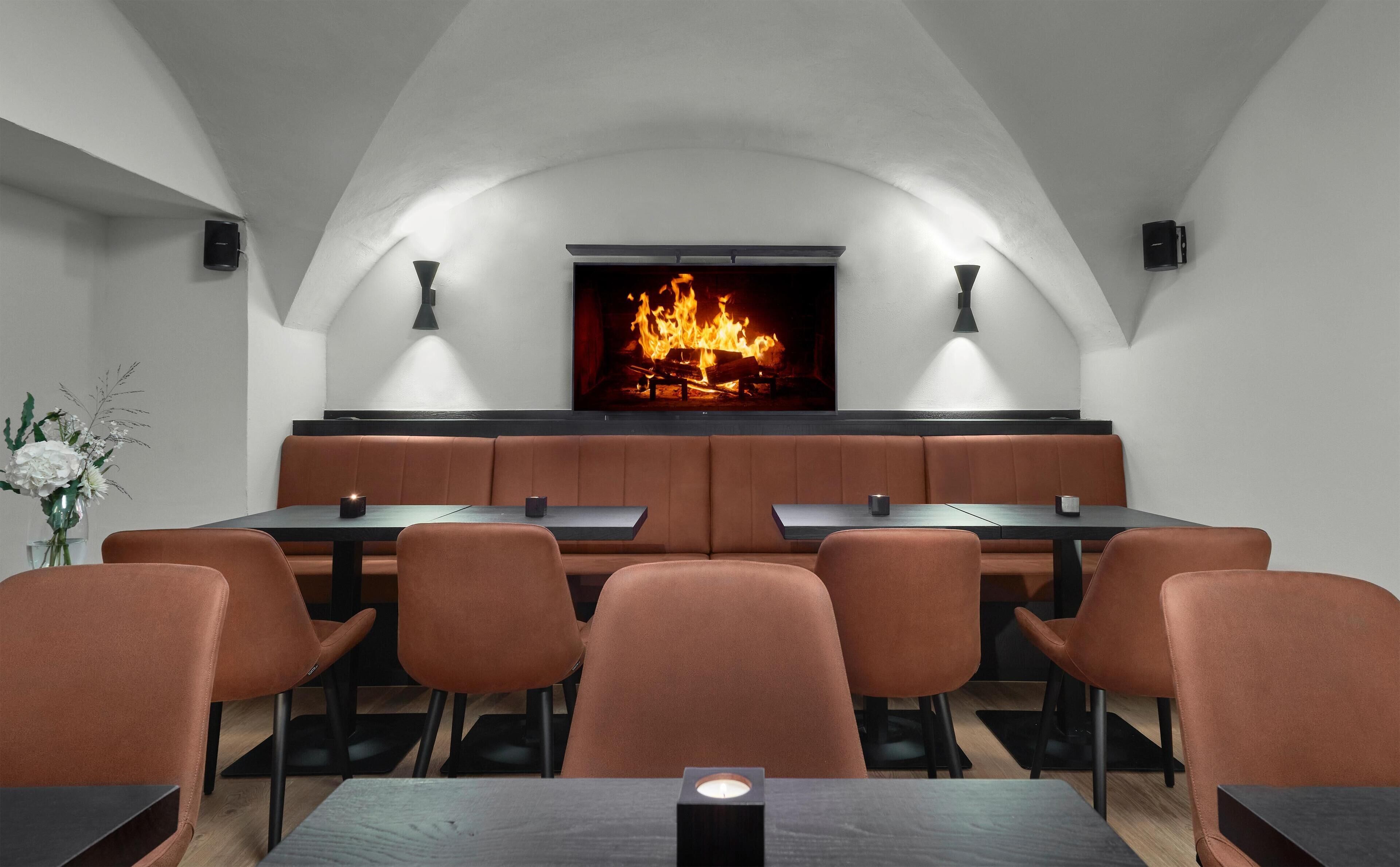 A restaurant with a fireplace, booths, and a long table.