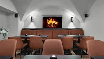 Un restaurante con chimenea, cabinas y una mesa larga.