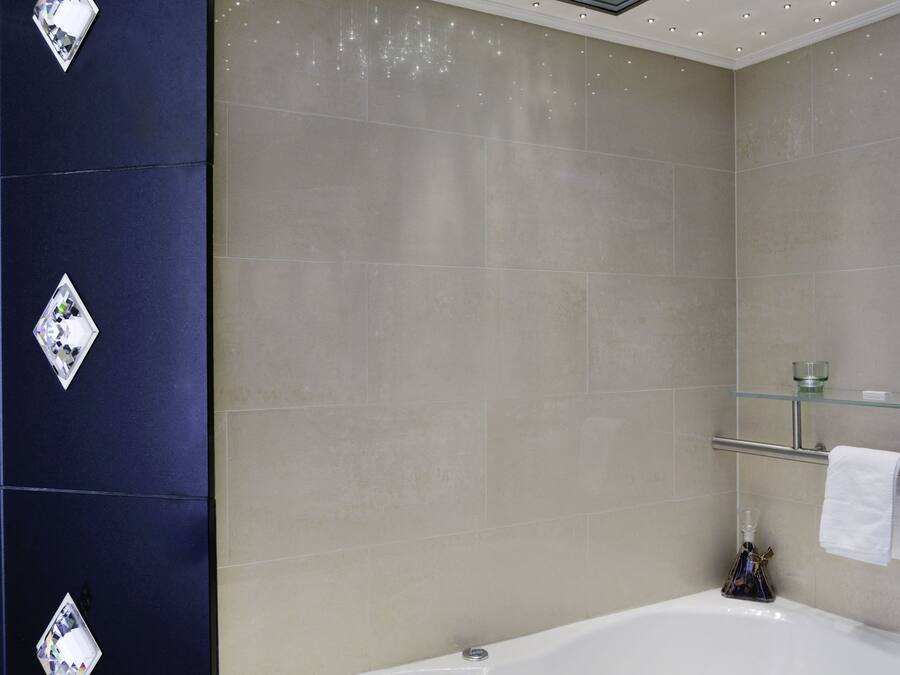 A modern bathroom with a freestanding bathtub, a glass-enclosed shower, and a mirror above the tub.