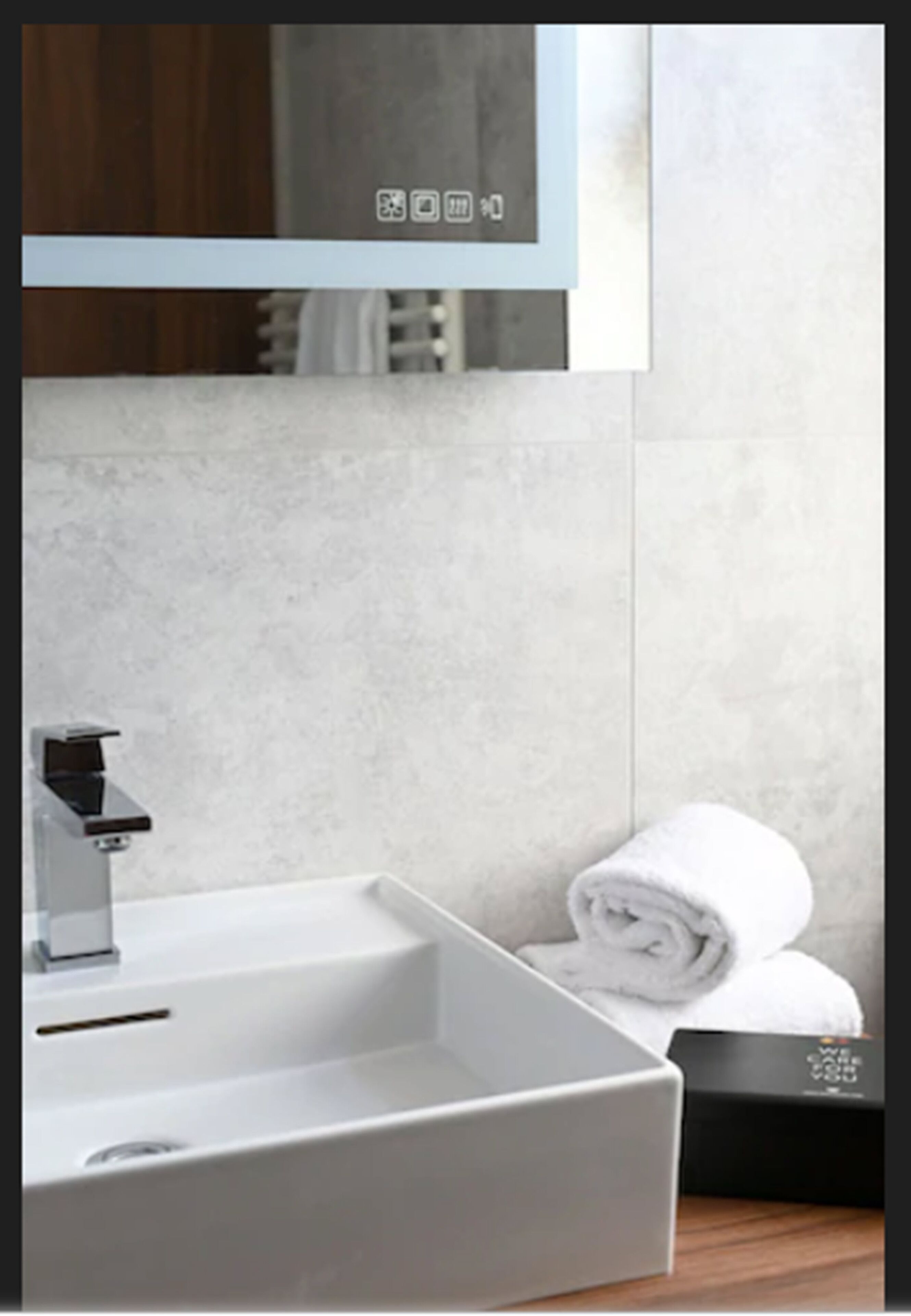 Un baño moderno con un lavamanos blanco, un espejo y una toalla.