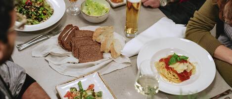 Uma mesa de jantar com diversos pratos, incluindo massa, pão e salada.