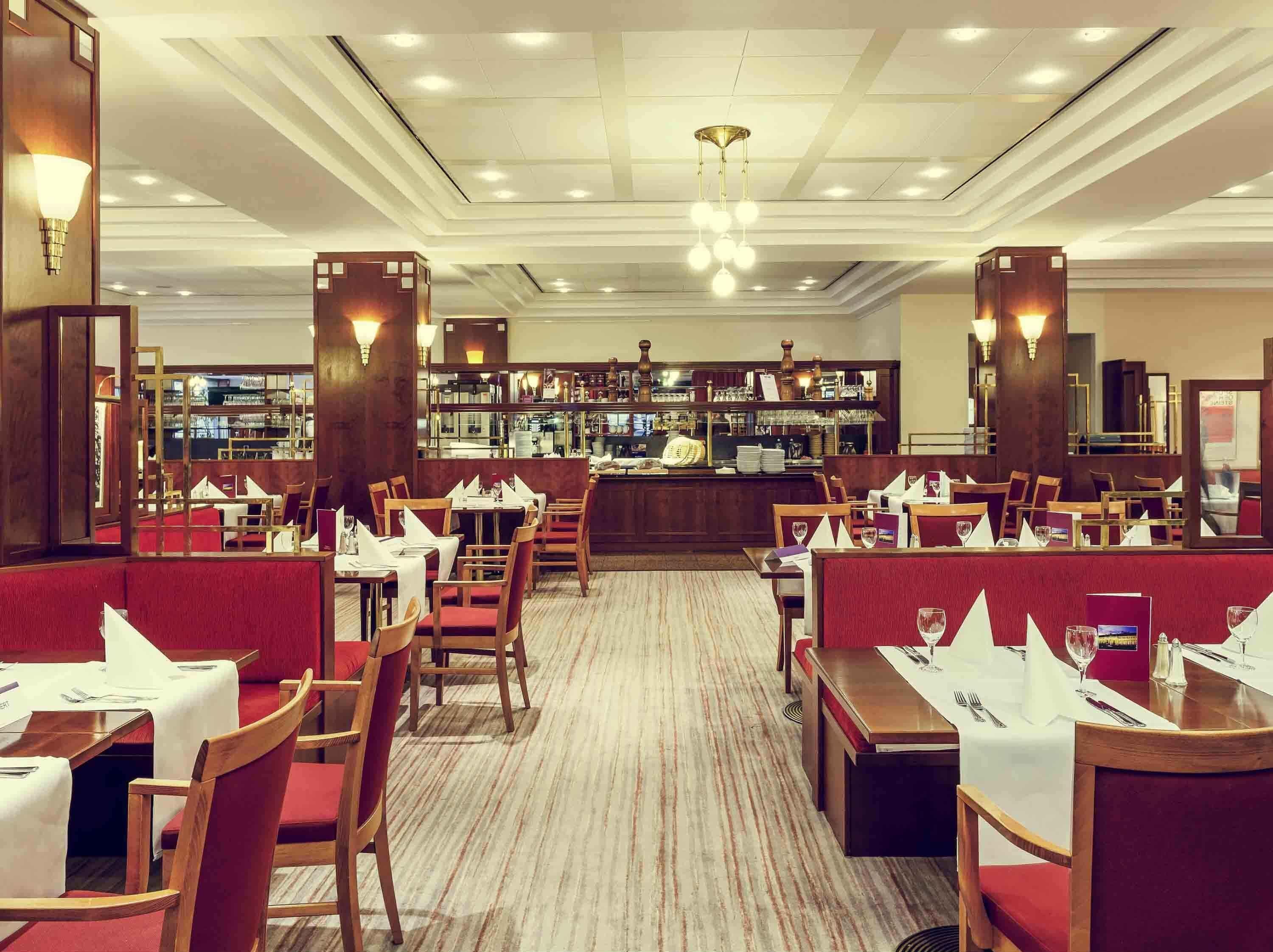 A restaurant with booths and tables, a bar area, and a carpeted floor.