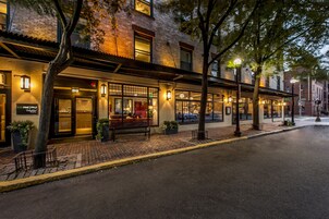 A brick building with a storefront, outdoor seating, and a street view.