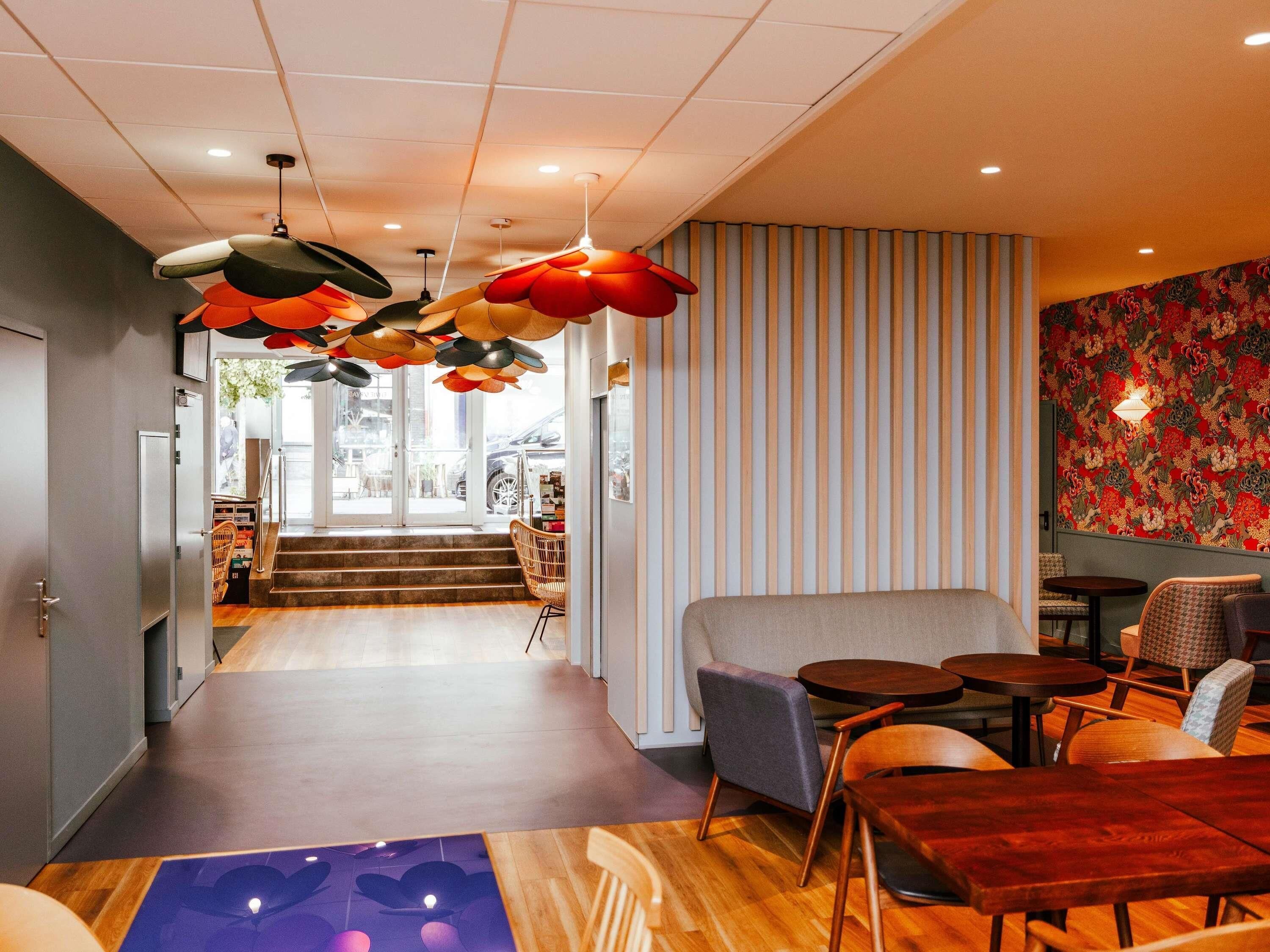Een modern interieur met een centraal zithoek, een trap naar een buitenruimte, en een patroonmuur.