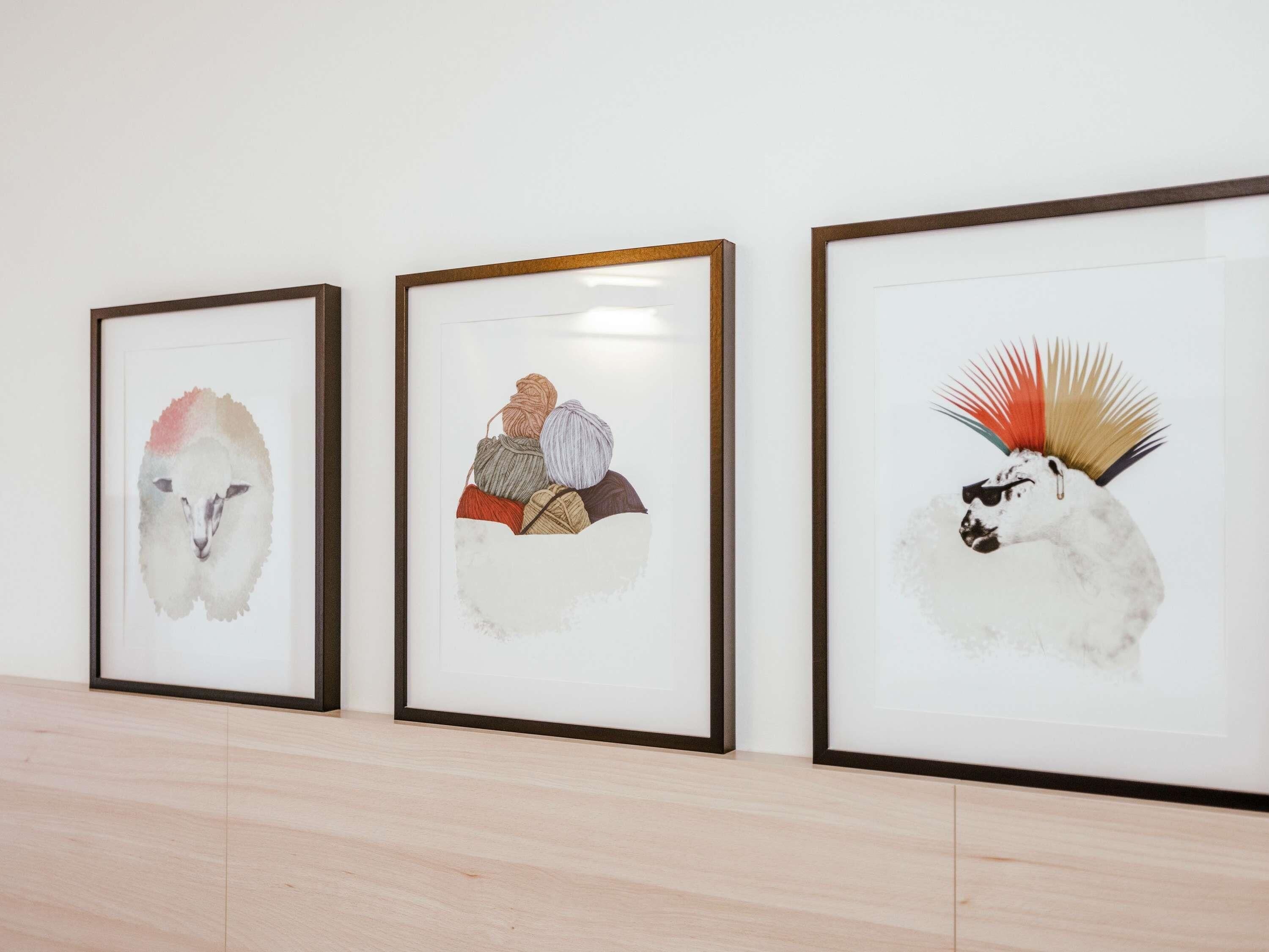Three framed artworks on a wall.
