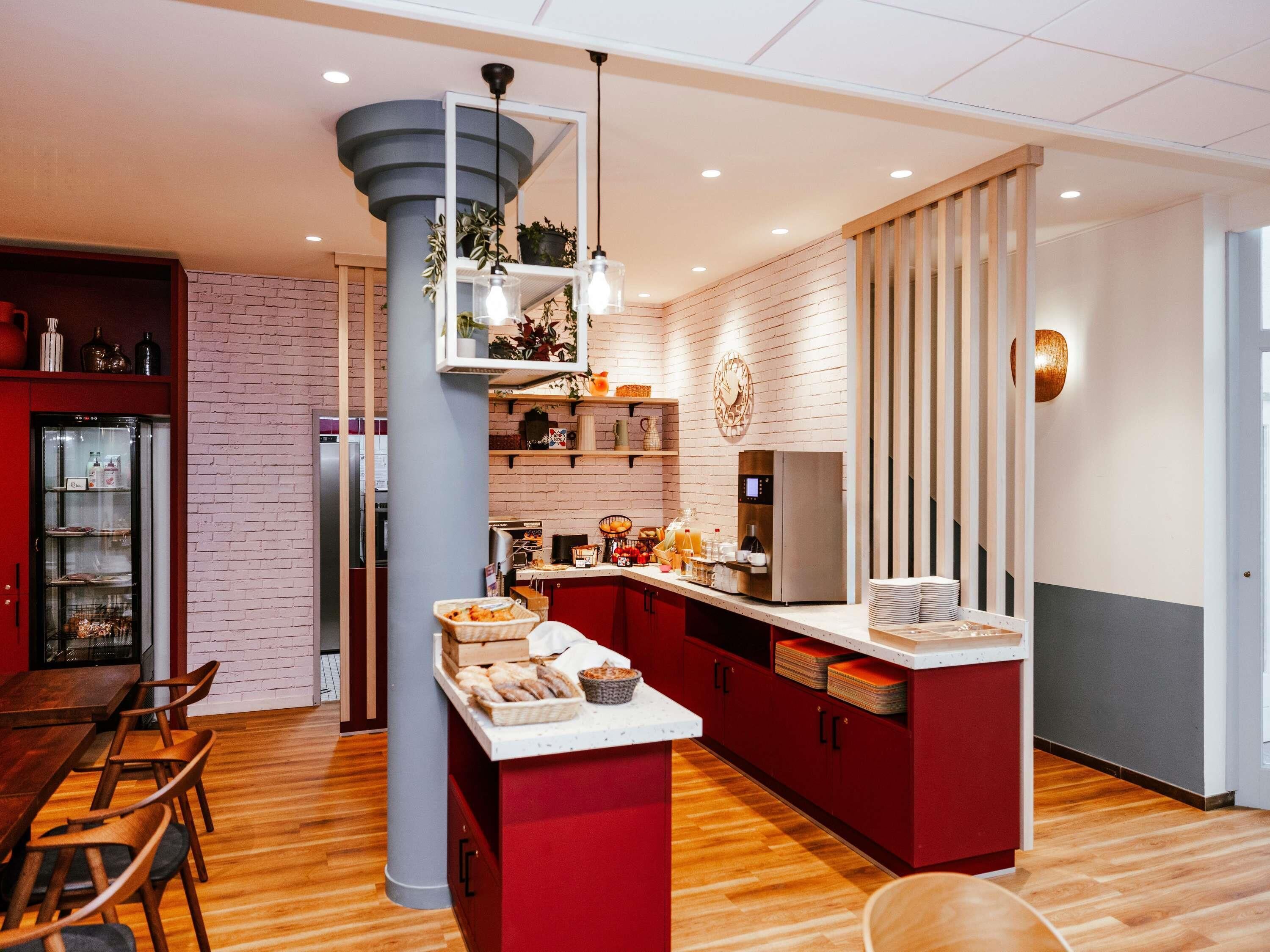 Una cocina moderna con una isla central, un refrigerador y una cafetera.