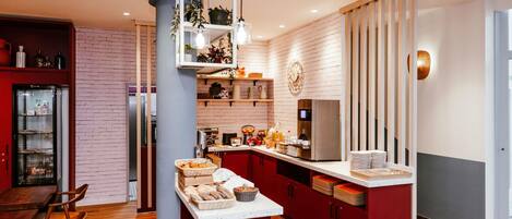 Una cocina moderna con una isla central, un refrigerador y una cafetera.