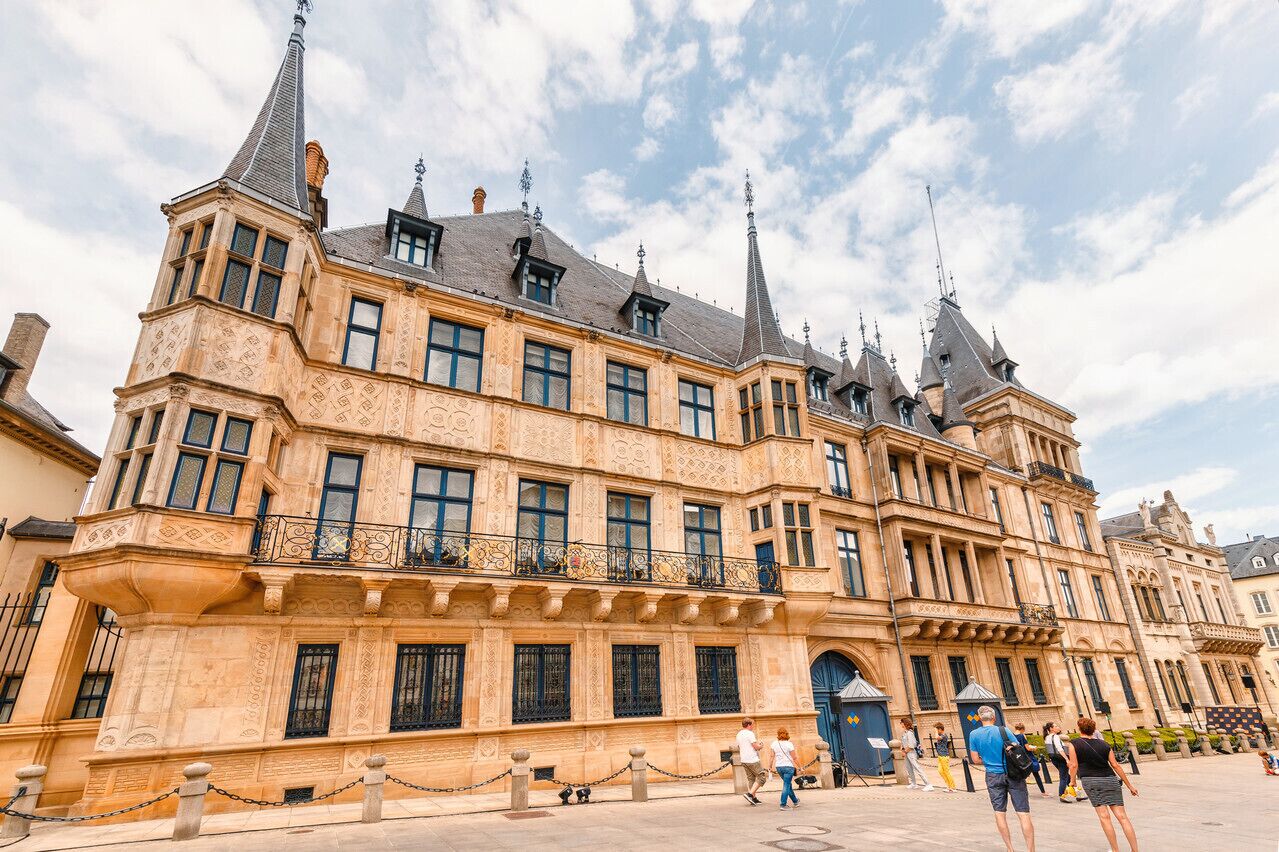 Un bâtiment historique aux façades richement décorées, doté de nombreuses flèches et d’une entrée imposante.