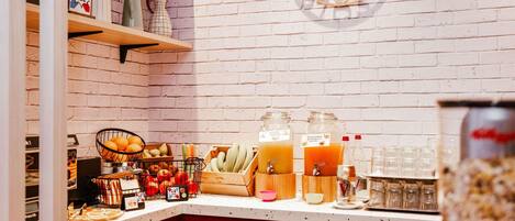 A kitchen counter with a fruit basket, a clock, and various kitchen items.