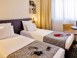 A hotel room with two beds, a desk, a chair, and a lamp. - Hôtel Mercure Lyon Centre Lumière (Lyon)