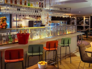 A bar area with a glass display case, multiple bar stools, and a variety of bottles and glasses.