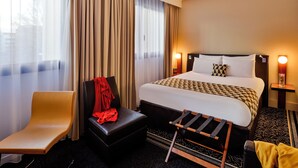 A hotel room with a bed, a chair, a small table, and a window with curtains. - Hôtel Mercure Lyon Centre Lumière (Lyon)