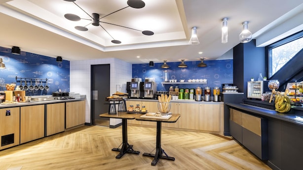 Una cocina moderna con armarios de madera, una isla central y diversos electrodomésticos y alimentos.
