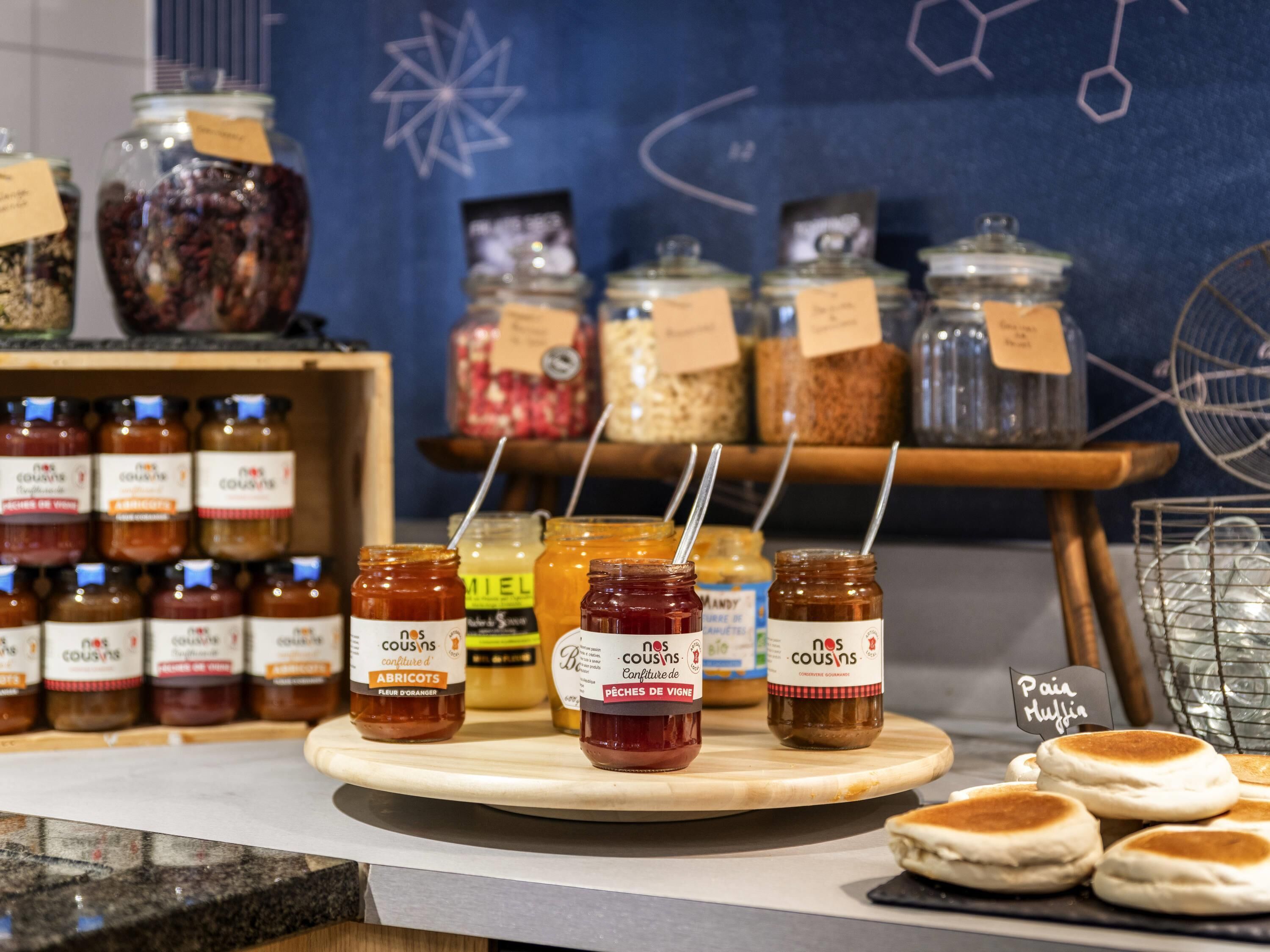 Diverse potjes met etiketten, sommige met rietjes, en een presentatie van muffins.