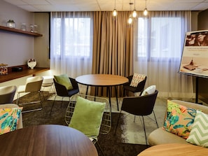 A conference room with a round table, chairs, a buffet table, and a banner. - Hôtel Mercure Lyon Centre Lumière (Lyon)