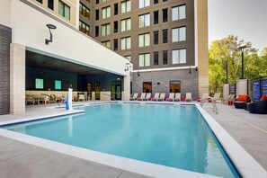 A modern hotel with a swimming pool, lounge chairs, and a covered seating area. - Drury Plaza Hotel North Charleston (North Charleston)