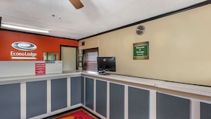 A reception area with a reception desk, a clock, and a welcome sign. - Econo Lodge Erlanger - Cincinnati Airport (Erlanger)
