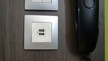 A wall-mounted power outlet with a Gigaset DA210 phone and a USB charging port.