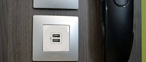 Un enchufe de pared con un teléfono Gigaset DA210 y un puerto de carga USB.