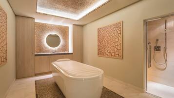 A modern bathroom with a freestanding bathtub, a glass-enclosed shower, and a skylight ceiling.