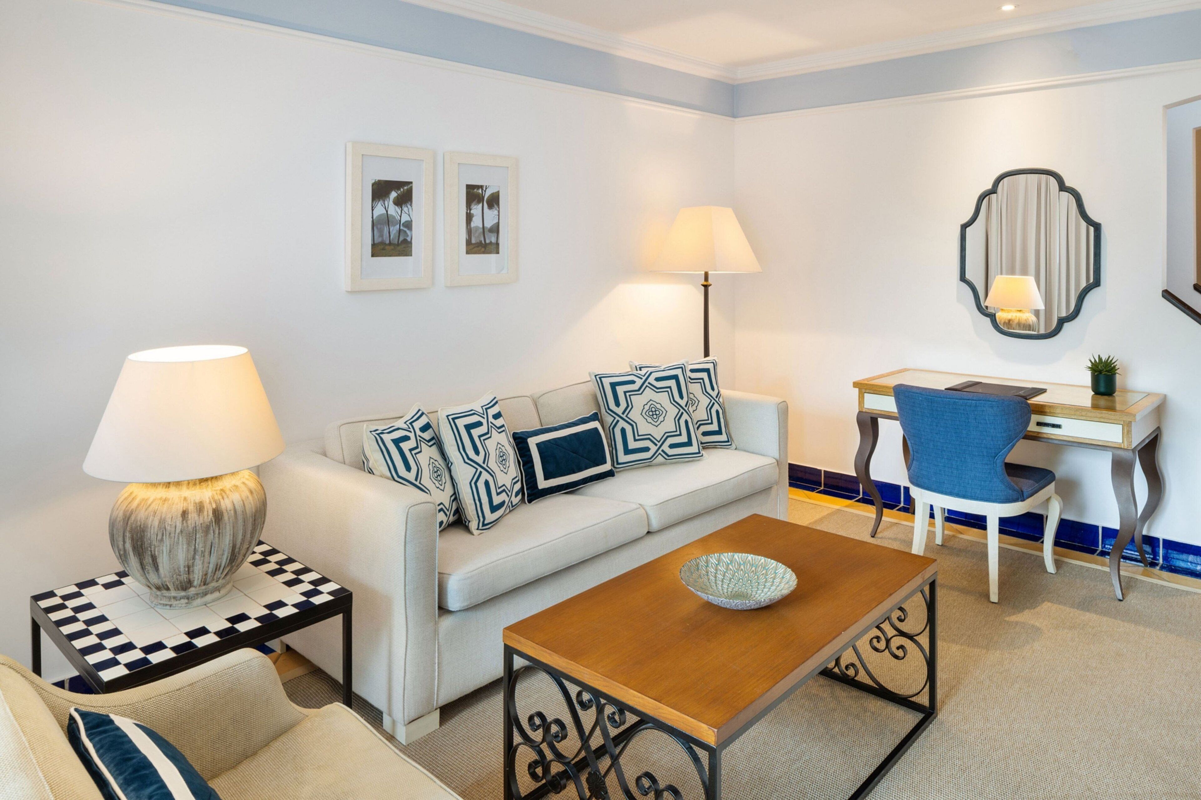 Uma sala de estar moderna com sofá, mesa de centro, mesa lateral e escrivaninha com cadeira.
