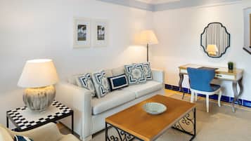 Uma sala de estar moderna com sofá, mesa de centro, mesa lateral e escrivaninha com cadeira.