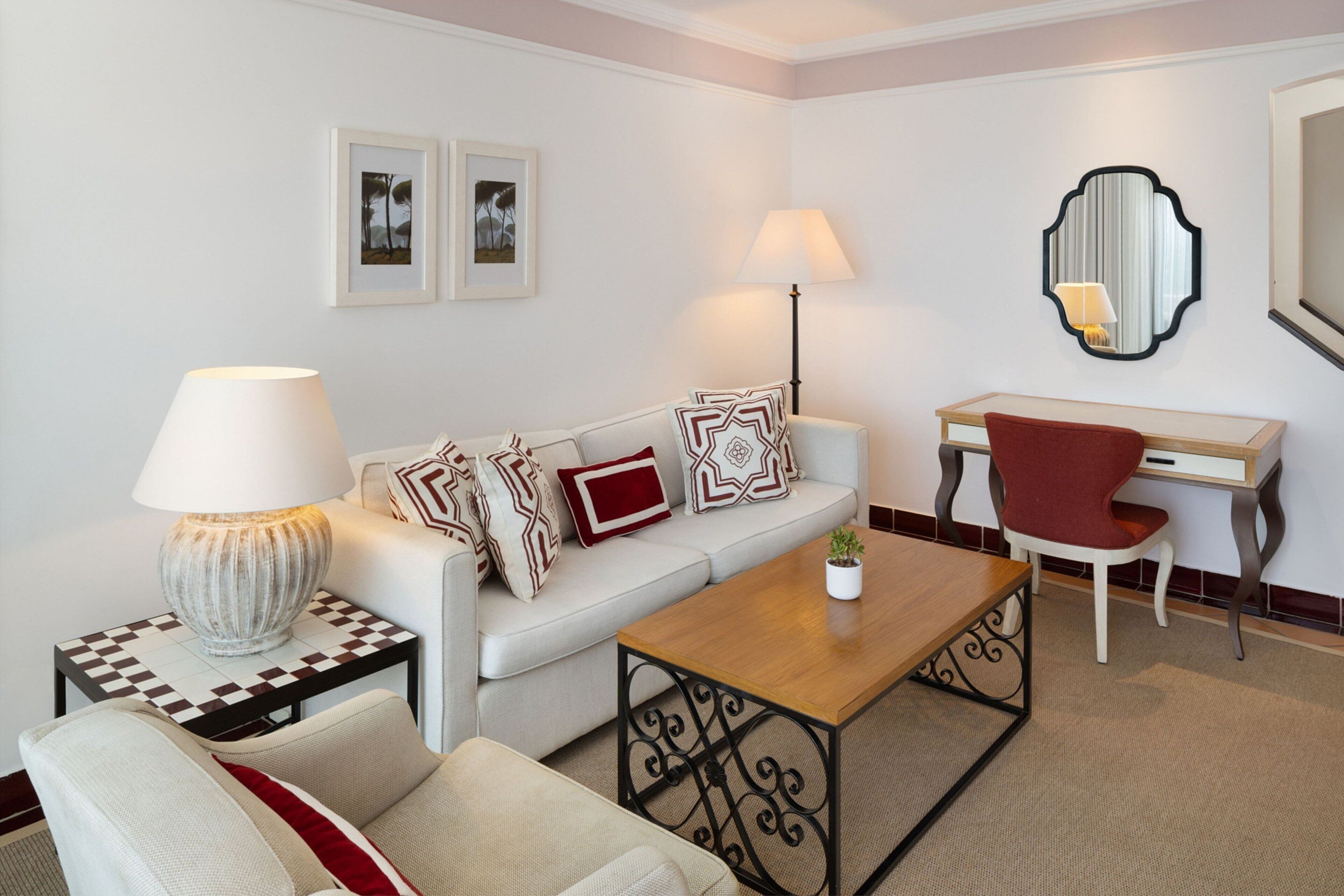 Una sala de estar moderna con sofá, sillón, mesa de centro, mesita auxiliar y escritorio.