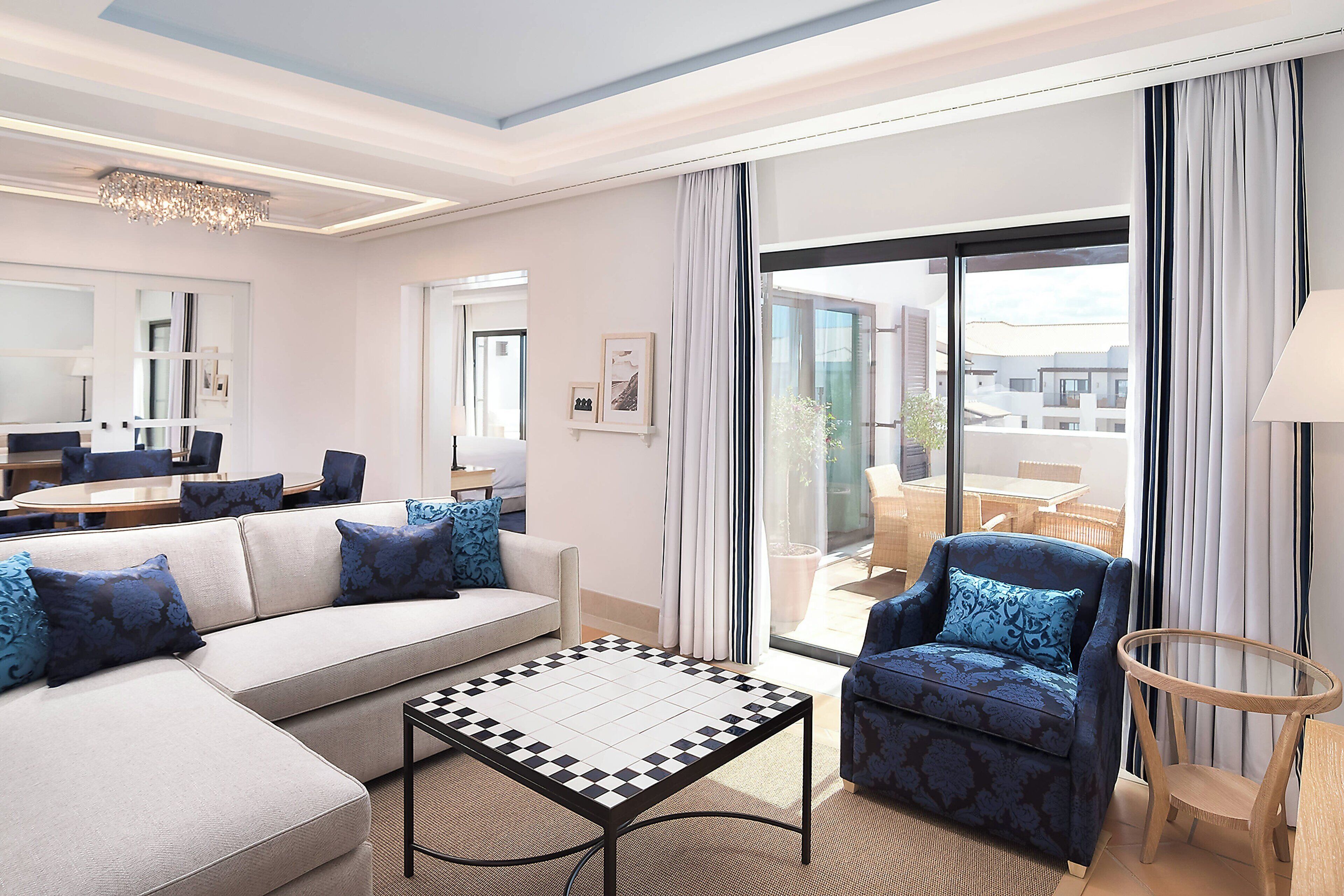Una sala de estar moderna con un sofá, sillones, una mesa de centro y vistas al exterior.