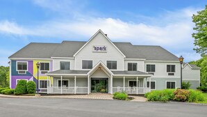 A two-story hotel with a prominent 'spark by Hilton' sign, a front porch, and a landscaped garden. - Spark by Hilton Brunswick (Brunswick)