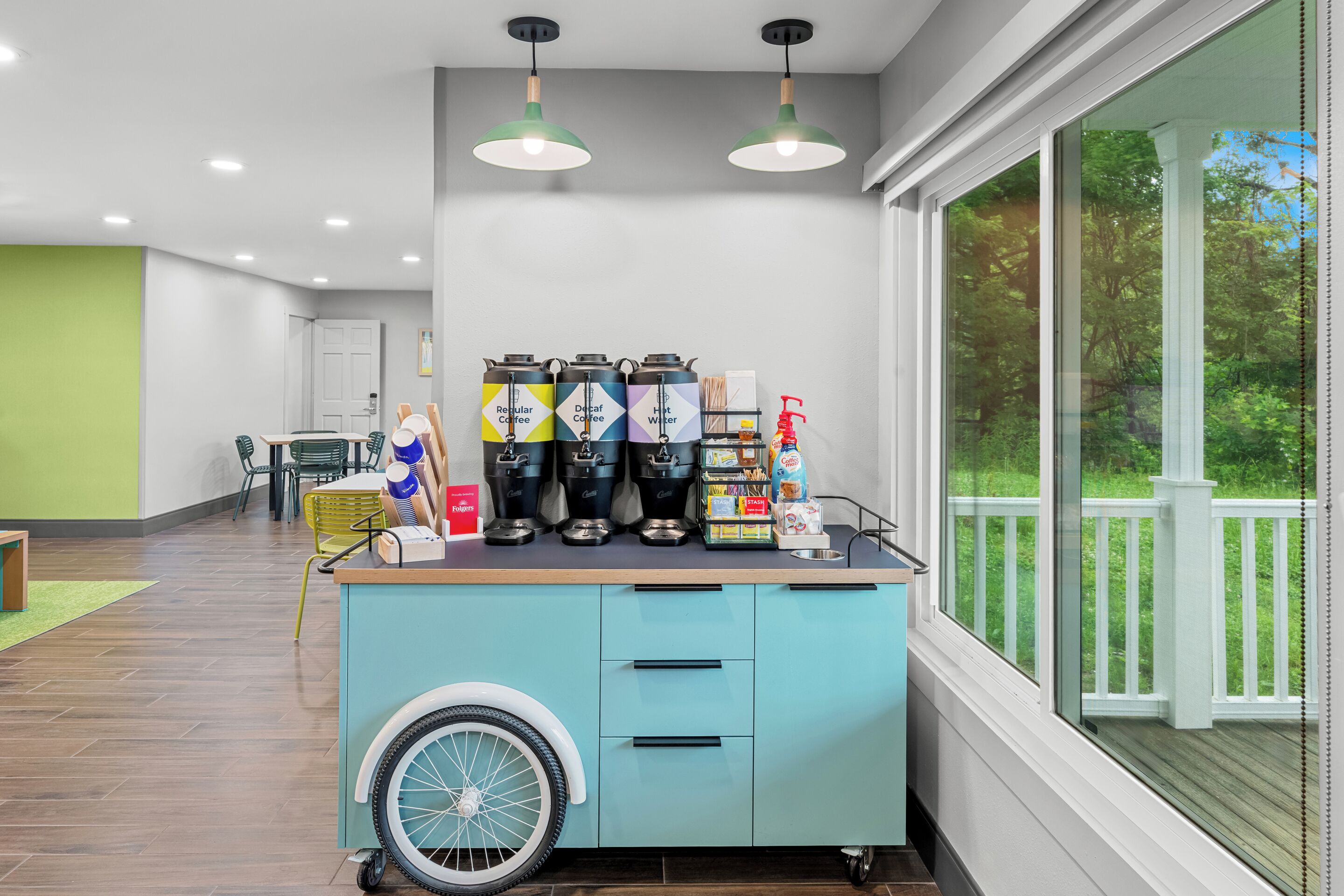 Un angolo cottura con angolo caffè, un carrello accessibile in sedia a rotelle e vista su una terrazza.