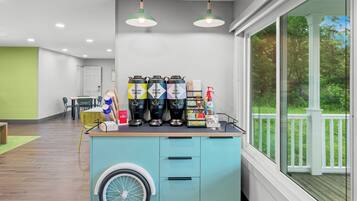 A kitchen area with a coffee station, a wheelchair-accessible cart, and a view of a deck.